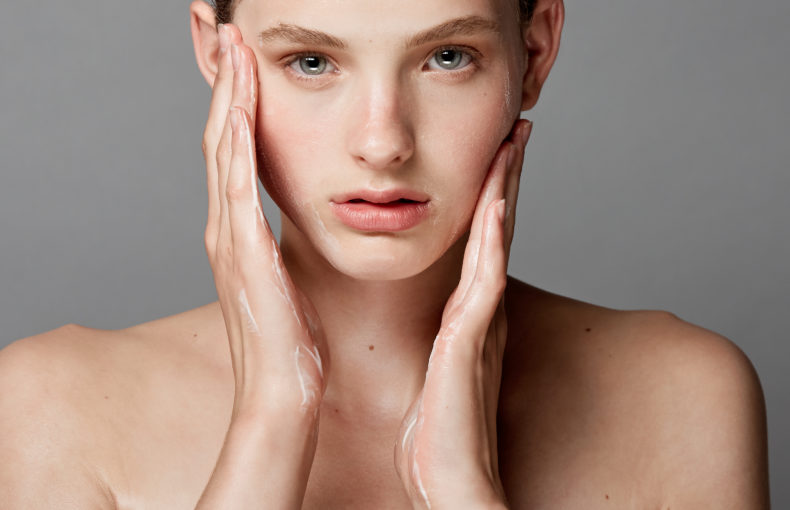 girl putting on facial moisturizer
