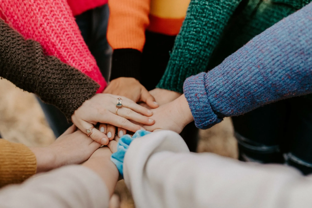 group of multiple hands stacked together 