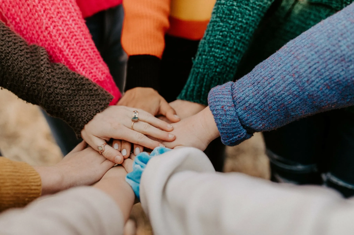 group of multiple hands stacked together